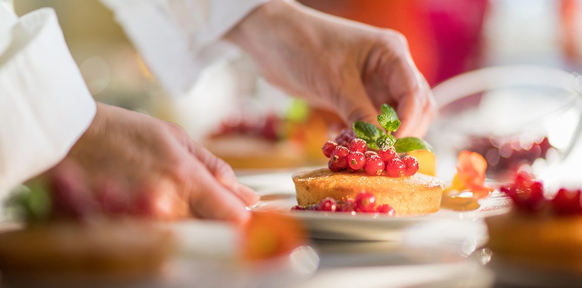 chef placing plate of food on table