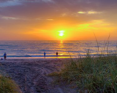 people on hutchinson island beach at sunset