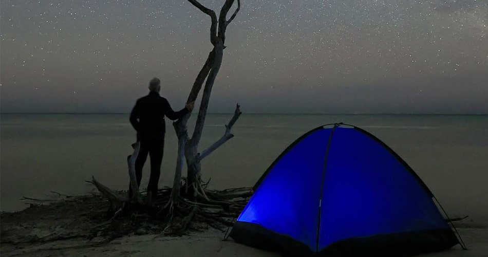 camper near water under stars