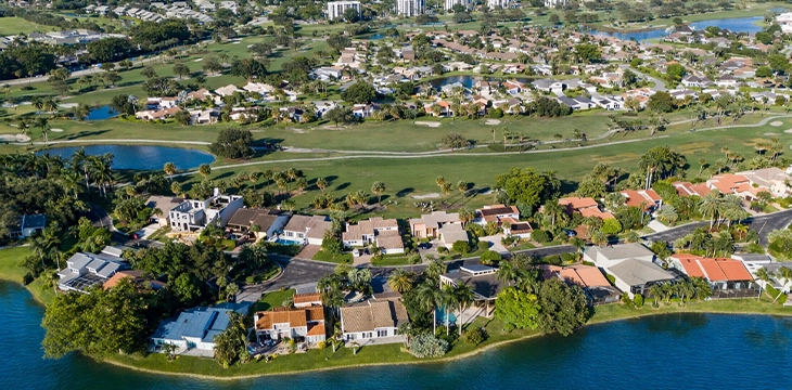 Aerial view of waterfront homes beside golf course and lakes