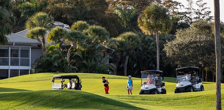 Golfers playing on a green with carts on a championship course