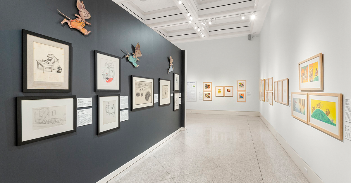 Modern art gallery with framed artwork and sculptures displayed on walls.