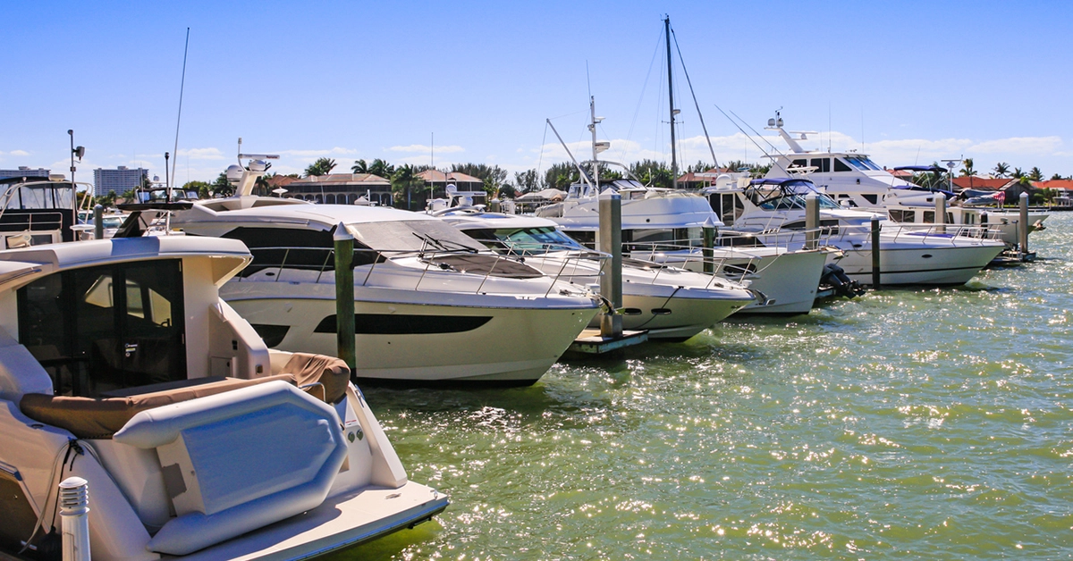 Luxury boats docked at a marina in Southwest Florida under a clear blue sky.